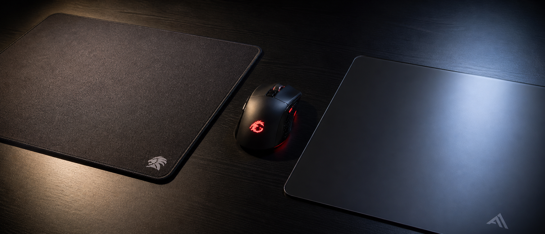 Cloth mousepad and hard mousepad side by side with a gaming mouse positioned between them, showing texture difference